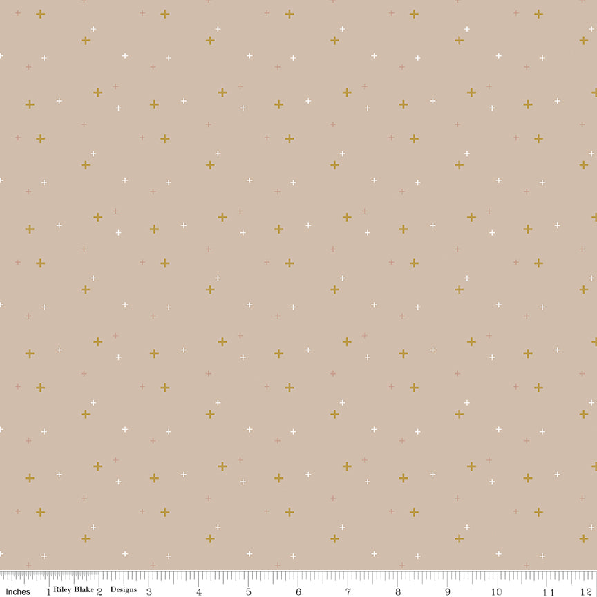 Riley Blake Sparkle Beach fabric featuring metallic gold plus signs of various sizes scattered on a sandy beige background with a ruler at the bottom for scale.