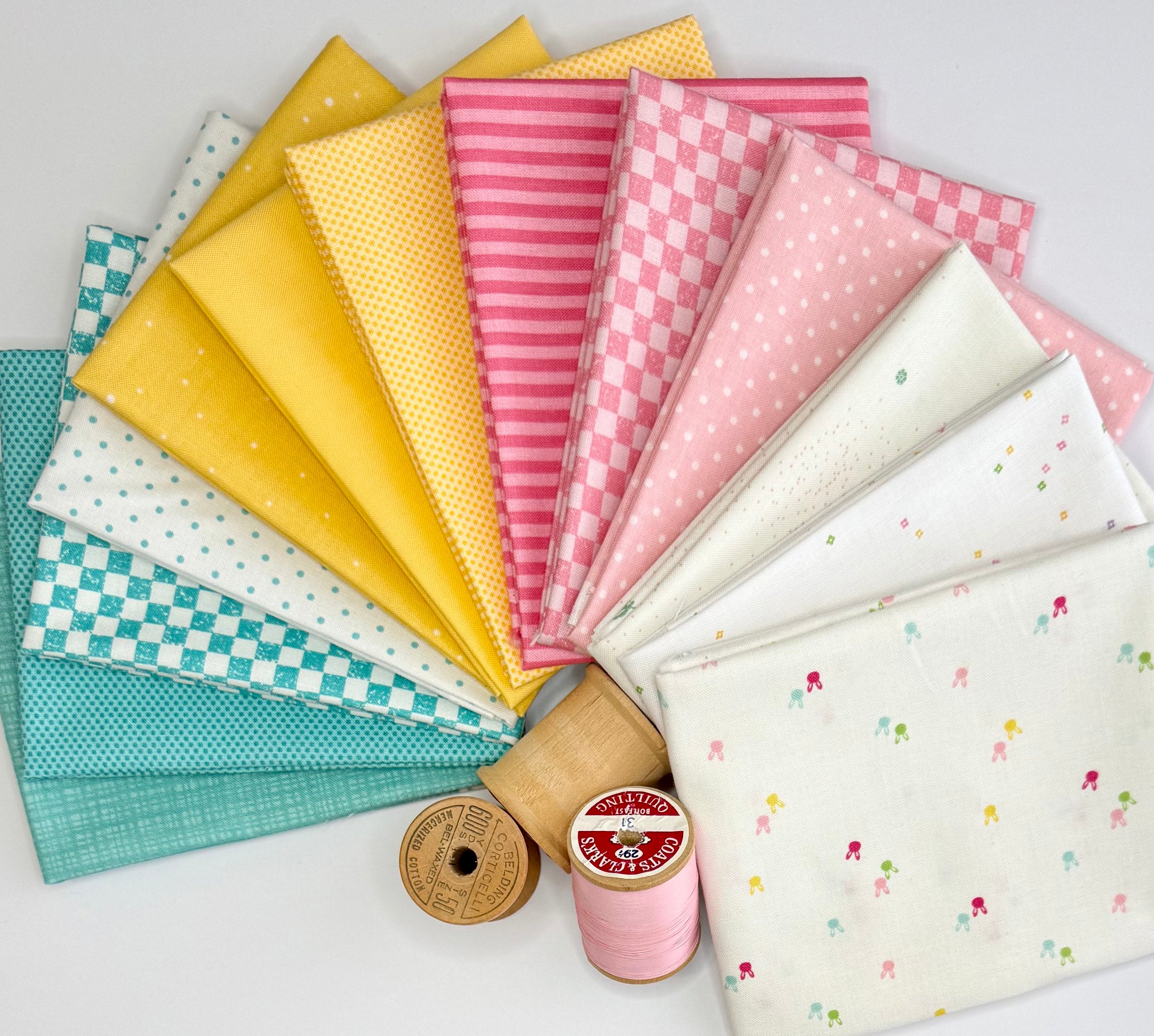 A fanned-out fabric bundle featuring Riley Blake Designs Basics in a palette of teal, yellow, pink, and white prints including checkers, stripes, and dots.